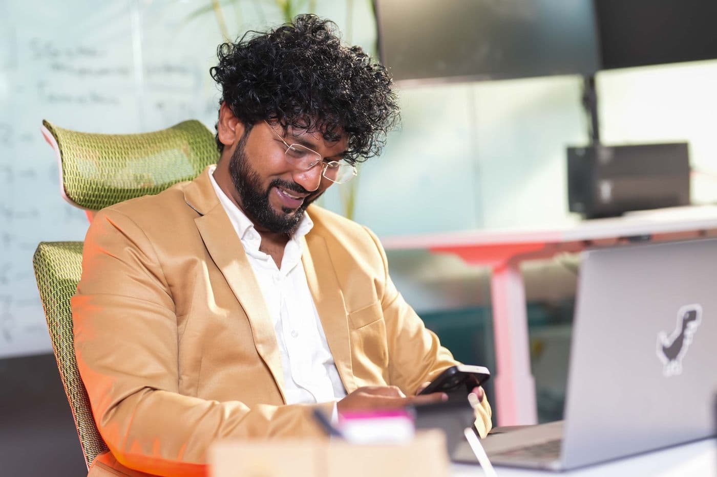 A professional smiling as he reads a shortlisting email on his phone