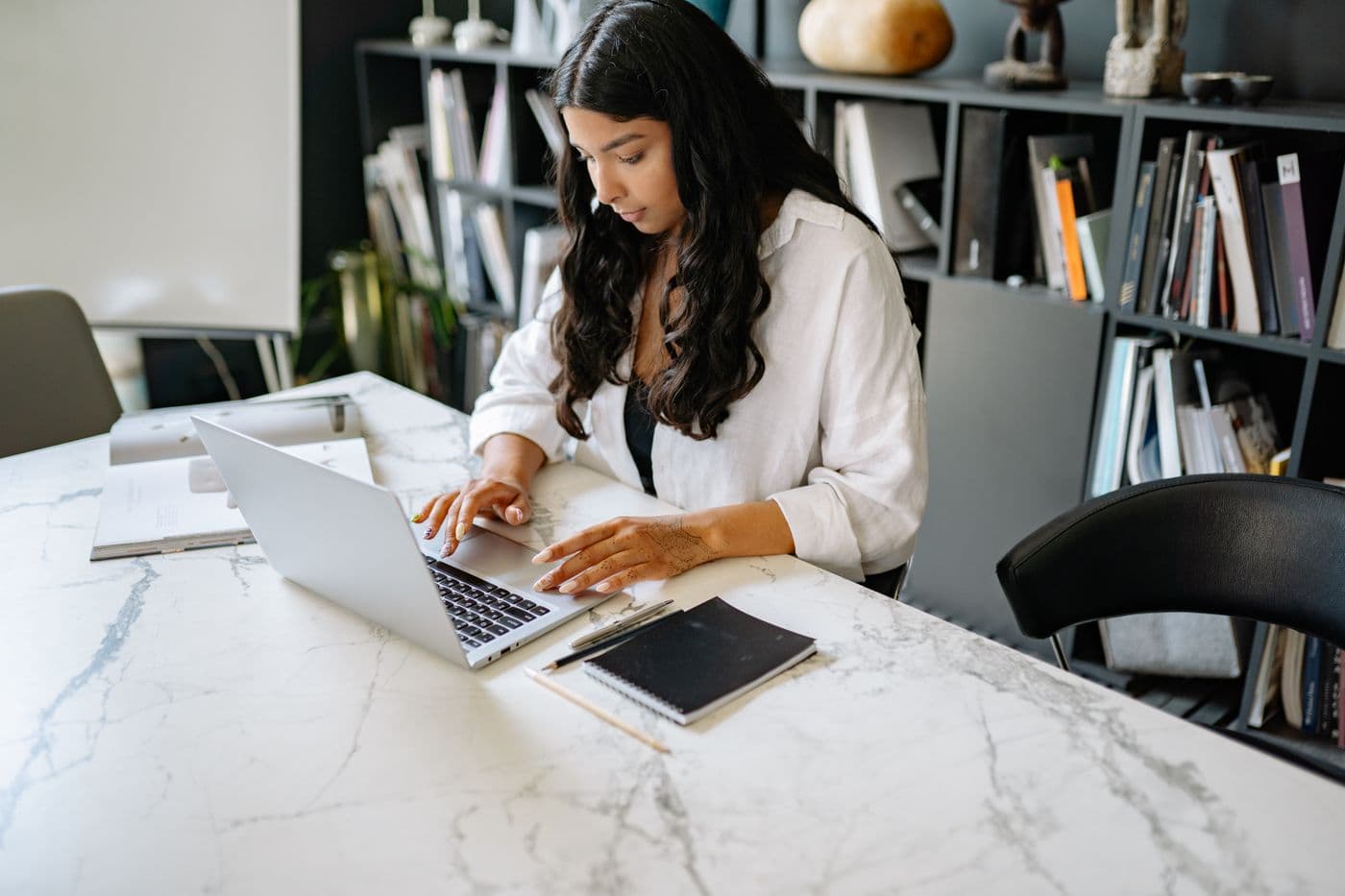 A professional working on her laptop at a desk
